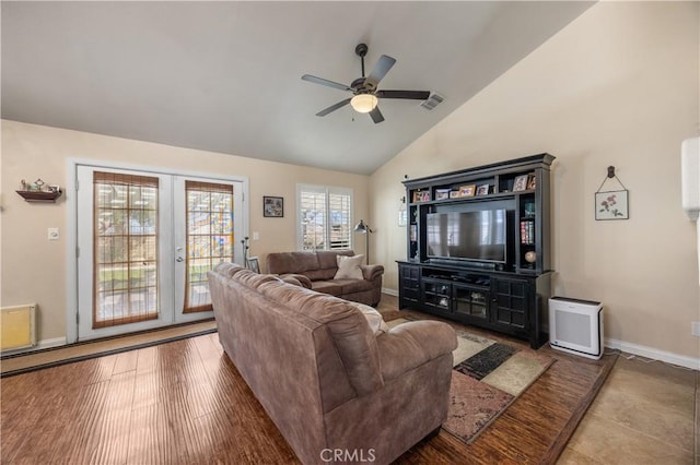 living area featuring visible vents, baseboards, vaulted ceiling, wood finished floors, and a ceiling fan