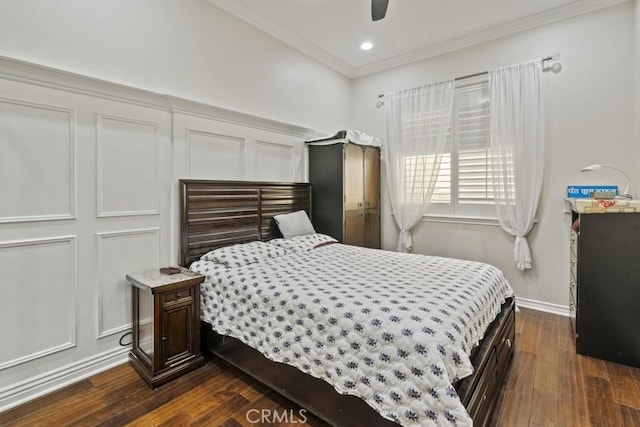 bedroom with ceiling fan, a decorative wall, baseboards, dark wood finished floors, and crown molding