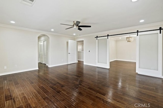 interior space with a barn door, visible vents, arched walkways, and wood finished floors