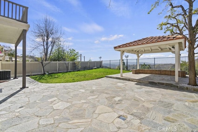 view of patio featuring a fenced backyard, central AC, and a gazebo