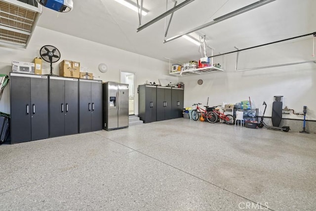 garage featuring stainless steel fridge and a garage door opener