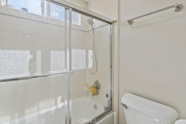 bathroom featuring toilet and enclosed tub / shower combo