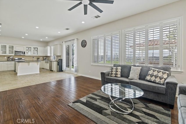 living area featuring recessed lighting, a ceiling fan, baseboards, visible vents, and light wood finished floors