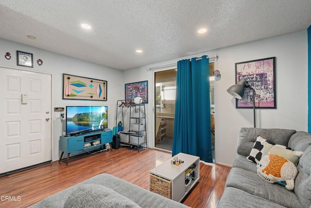 living room featuring a textured ceiling, wood finished floors, and recessed lighting