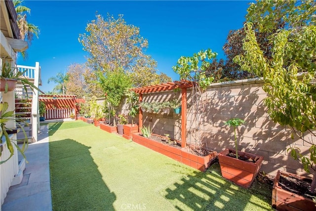 view of yard featuring a fenced backyard, a vegetable garden, and a pergola