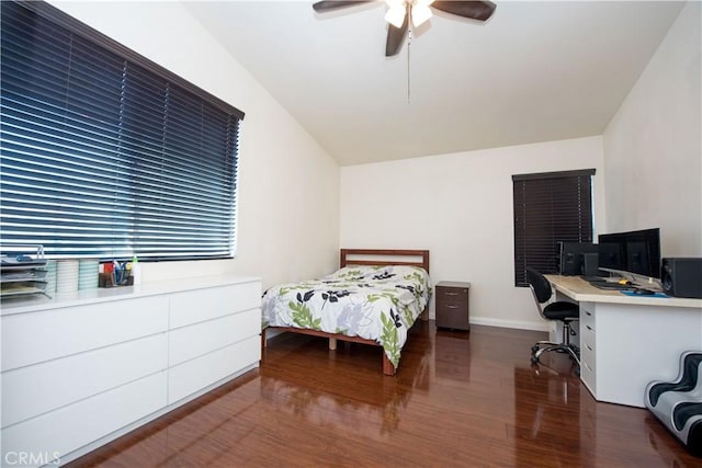 bedroom featuring a ceiling fan, vaulted ceiling, baseboards, and wood finished floors