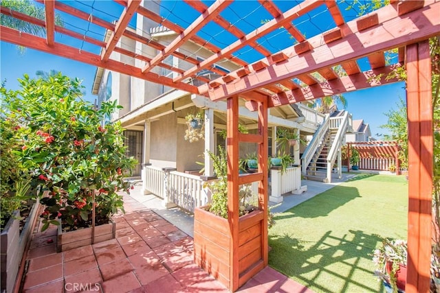 view of patio with fence, stairway, and a pergola