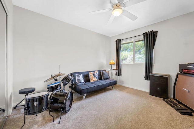 carpeted living area featuring ceiling fan and baseboards