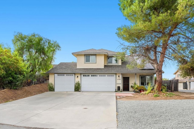 traditional-style house with concrete driveway, solar panels, covered porch, fence, and stucco siding