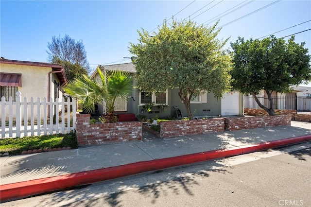 obstructed view of property featuring fence, an attached garage, and stucco siding