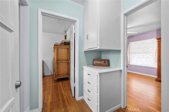 hallway featuring baseboards and wood finished floors