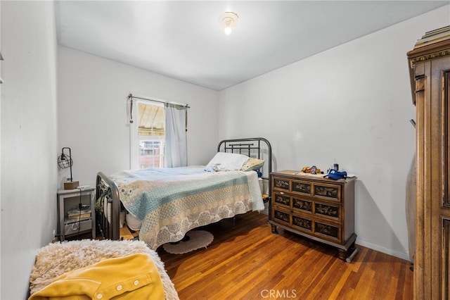 bedroom with wood finished floors and baseboards