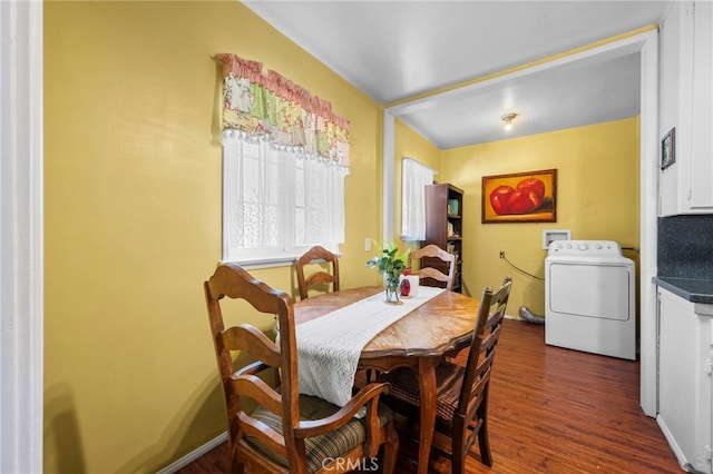 dining space with dark wood-style floors, washer / dryer, and baseboards