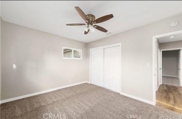 unfurnished bedroom with carpet floors, a closet, a ceiling fan, and baseboards