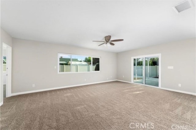 spare room featuring carpet, visible vents, ceiling fan, and baseboards