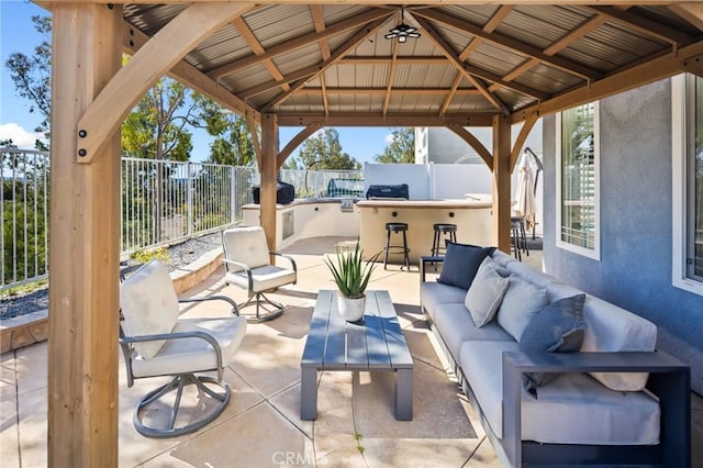 view of patio / terrace with outdoor lounge area, a gazebo, fence, and outdoor dry bar