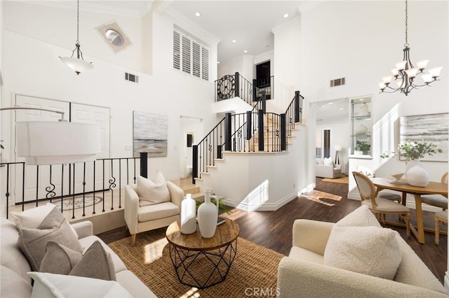 living area featuring visible vents, ornamental molding, stairs, and wood finished floors