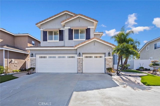 view of front of home featuring stucco siding, a tile roof, stone siding, concrete driveway, and an attached garage