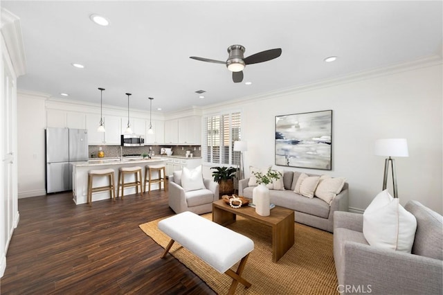 living room with dark wood finished floors, recessed lighting, ceiling fan, and ornamental molding