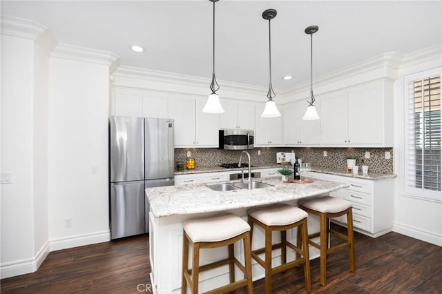 kitchen featuring decorative backsplash, ornamental molding, stainless steel appliances, and a sink