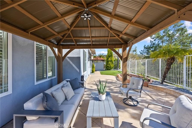 view of patio with an outdoor living space, a gazebo, and fence