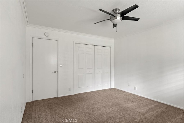 unfurnished bedroom with ornamental molding, a closet, carpet flooring, and a ceiling fan