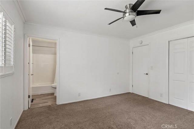 unfurnished bedroom with carpet floors, crown molding, ceiling fan, and ensuite bathroom