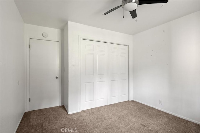 unfurnished bedroom with carpet, a closet, and ceiling fan