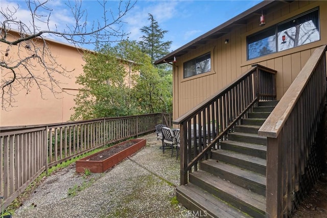 exterior space with stairs, a vegetable garden, and fence