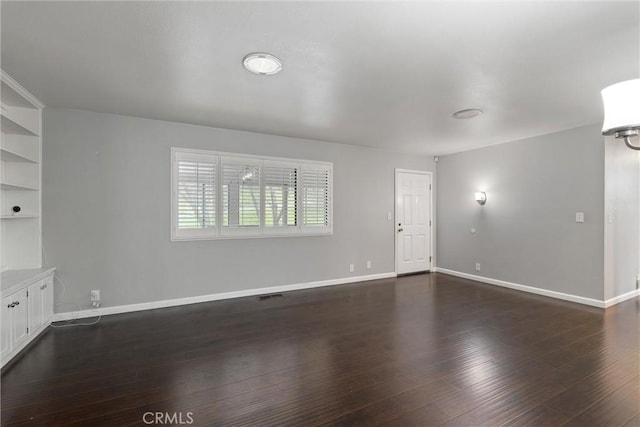 unfurnished living room with dark wood-style floors, visible vents, and baseboards