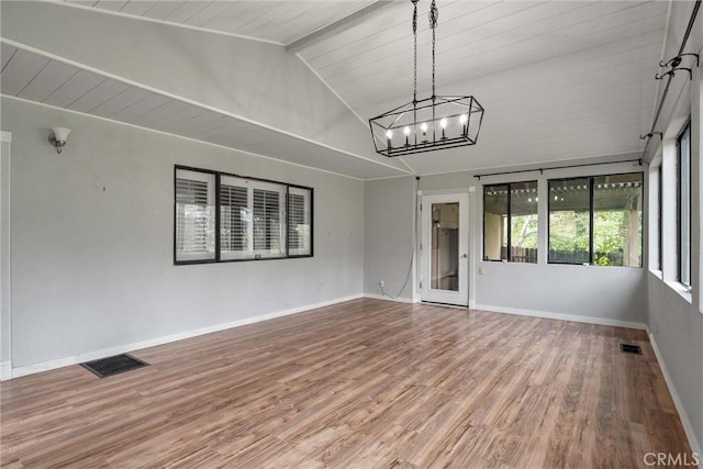 spare room with vaulted ceiling with beams, wood finished floors, visible vents, and baseboards