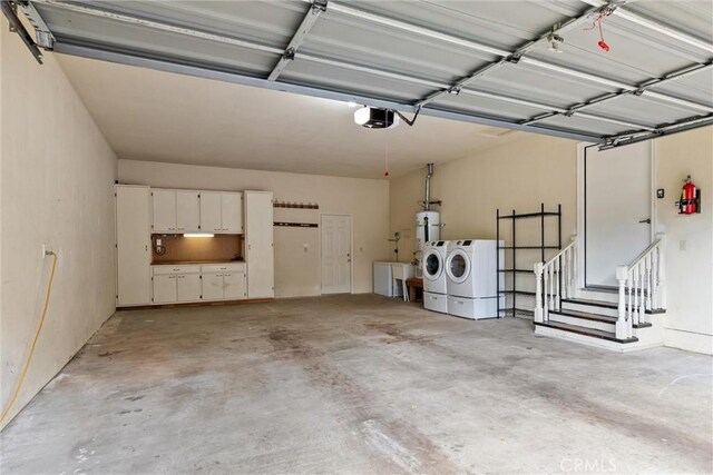 garage with water heater, washer and dryer, and a garage door opener