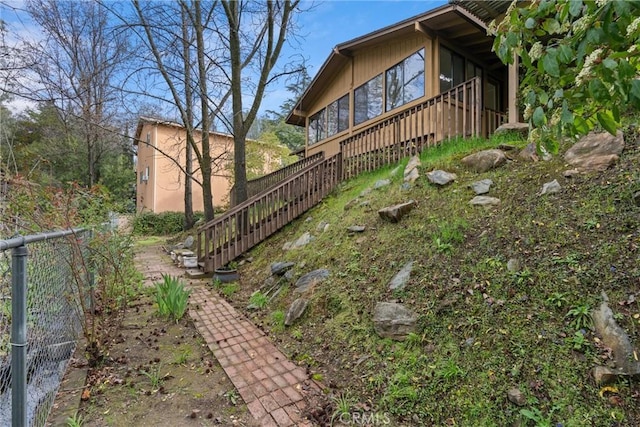 view of property exterior with stairway and fence