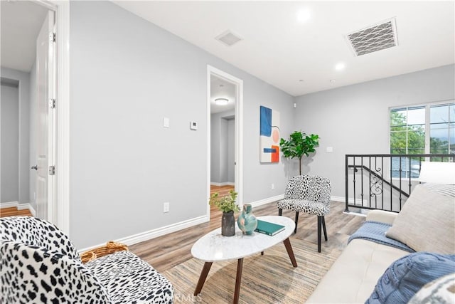 living room featuring light wood finished floors, visible vents, recessed lighting, and baseboards