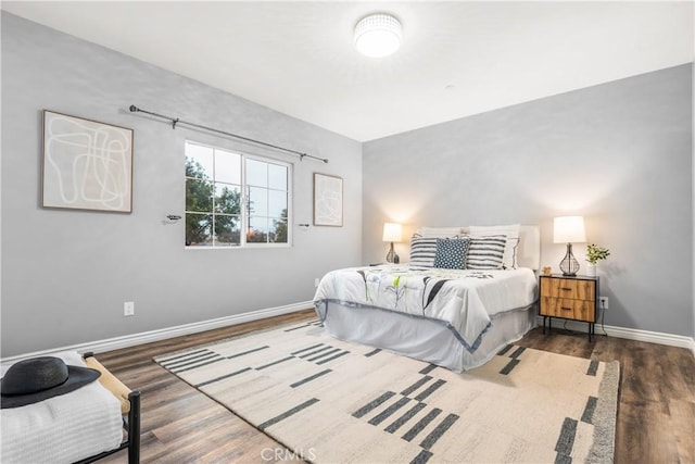 bedroom featuring baseboards and wood finished floors