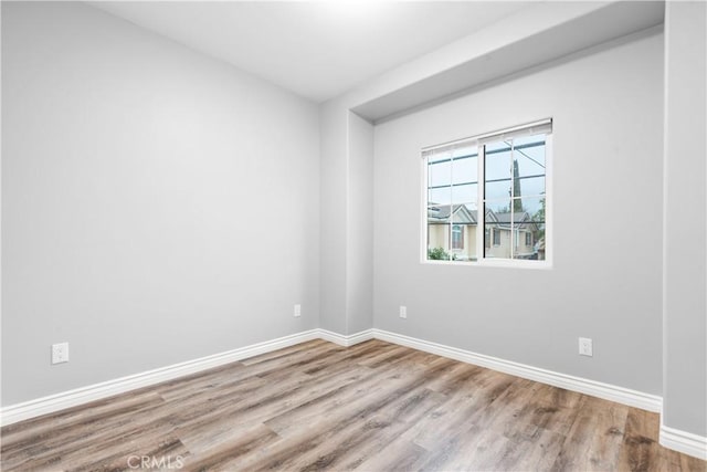 spare room with wood finished floors and baseboards