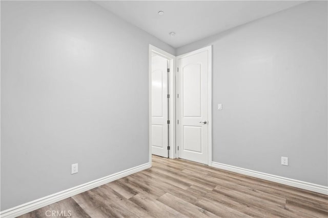 unfurnished room featuring baseboards and wood finished floors