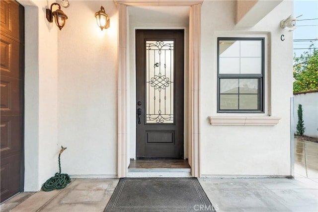 doorway to property featuring stucco siding