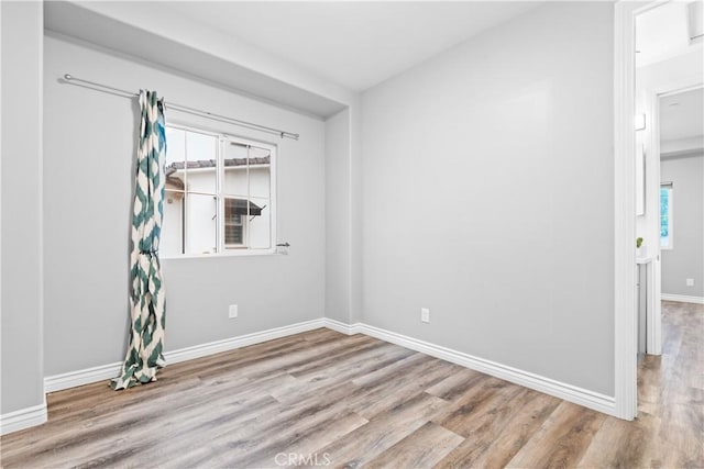 empty room featuring wood finished floors and baseboards