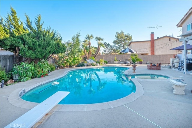 view of pool with a fenced in pool, a fenced backyard, a patio, and a diving board