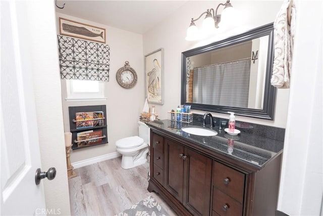 full bath with vanity, wood finished floors, toilet, and baseboards