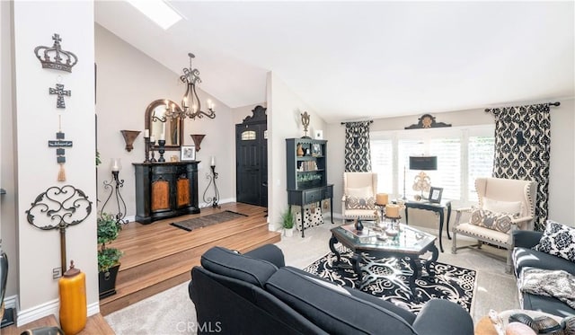 living area with high vaulted ceiling, a notable chandelier, baseboards, and wood finished floors