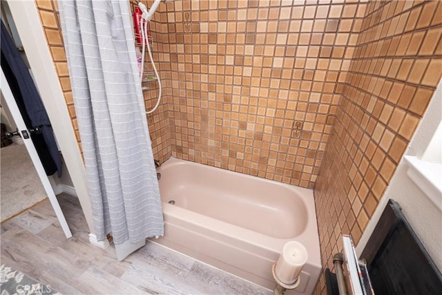 bathroom featuring shower / tub combo and wood finished floors