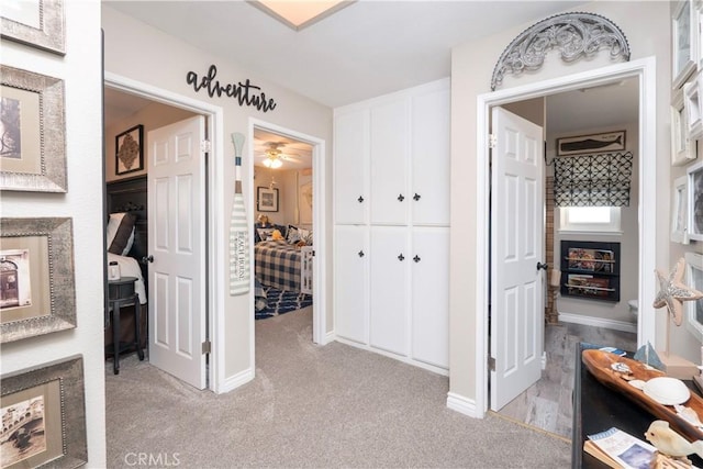 hallway with light colored carpet and baseboards