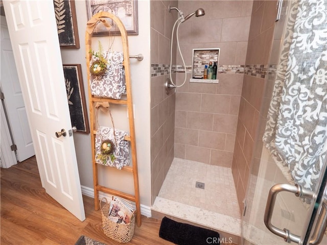 full bathroom featuring a stall shower and wood finished floors