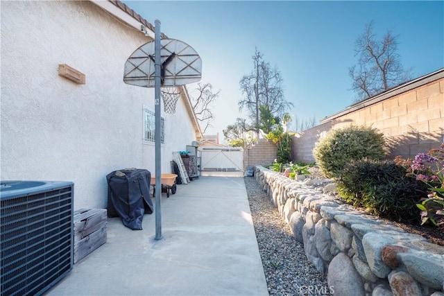 view of patio / terrace with area for grilling, fence, a gate, and central air condition unit