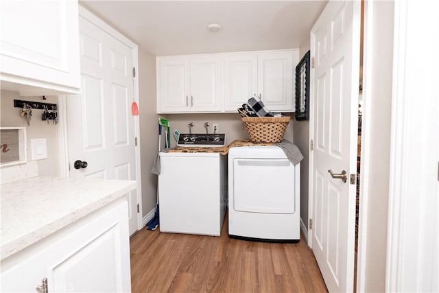 laundry room featuring cabinet space, washer and clothes dryer, and light wood finished floors