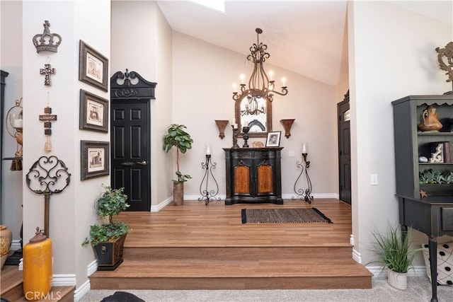 interior space with vaulted ceiling, baseboards, wood finished floors, and a notable chandelier