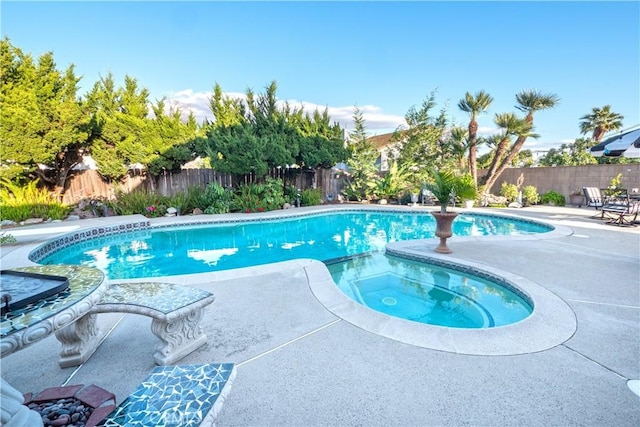 view of pool featuring a patio area, a fenced backyard, and a pool with connected hot tub