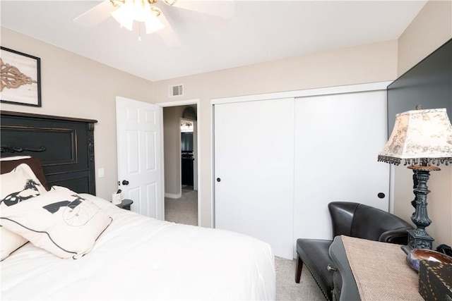 bedroom with ceiling fan, visible vents, a closet, and light colored carpet